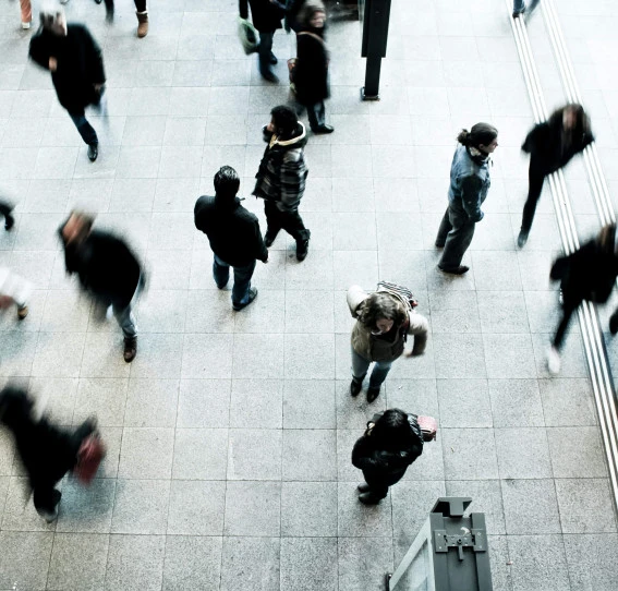 aerial view of blurred people walking different directions on a platform