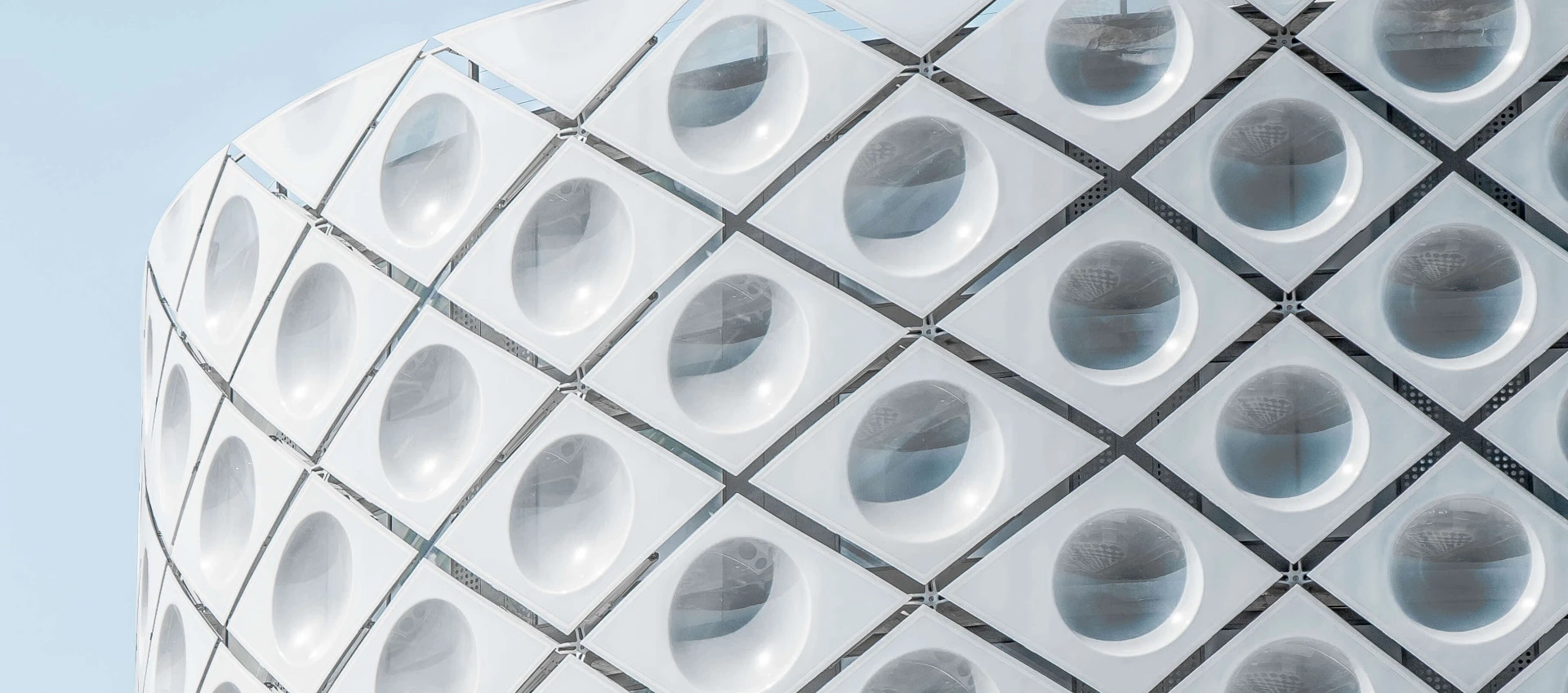 outer white building with unusual design with a blue sky background