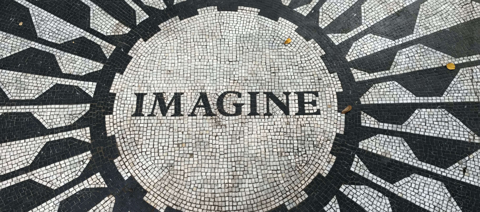 several people celebrating holi festival with pink powder covering the crowd the word "imagine" positioned in a circle on a black and white patio