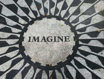 several people celebrating holi festival with pink powder covering the crowd the word "imagine" positioned in a circle on a black and white patio
