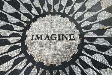 several people celebrating holi festival with pink powder covering the crowd the word "imagine" positioned in a circle on a black and white patio