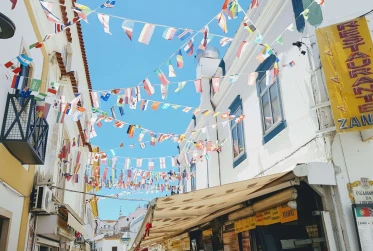 low angle view of bunting of several international flags attached to opposite buildings