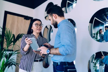 low angle view of two people interacting while they both hold tablet device