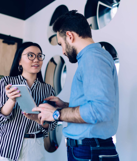 low angle view of two people interacting while they both hold tablet device