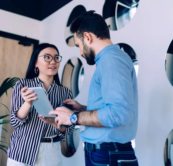low angle view of two people interacting while they both hold tablet device