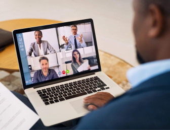 split screen of four people on video call on laptop