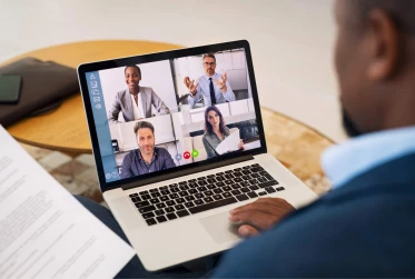 split screen of four people on video call on laptop