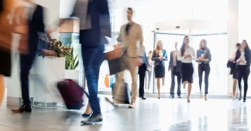 a lobby with blurred business men and women walking in