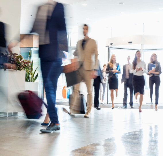 a lobby with blurred business men and women walking in