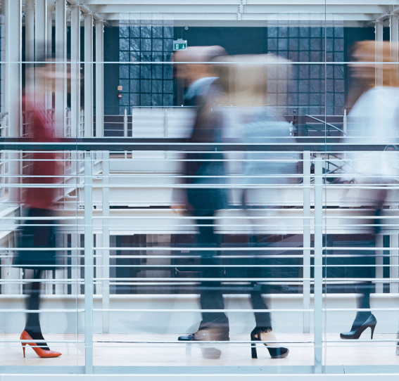 An abstract image of people walking in a professional setting.
