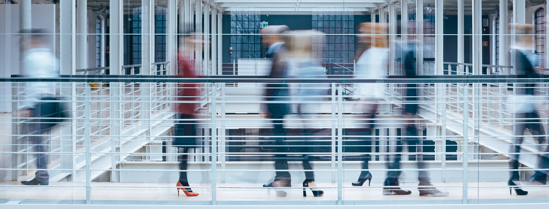 An abstract image of people walking in a professional setting.