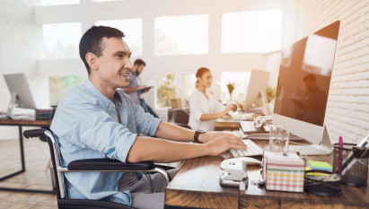 man smiling sitting in wheelchair working in office