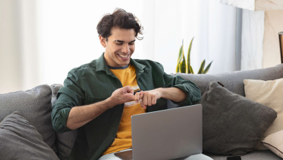 man on sofa smiling doing sign language on laptop