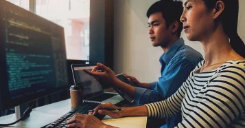 two people working together on computer