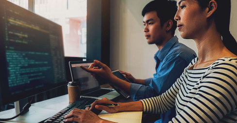 two people working together on computer