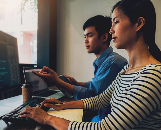 two people working together on computer