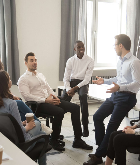 gathering of seven people wearing smart clothing talking in office