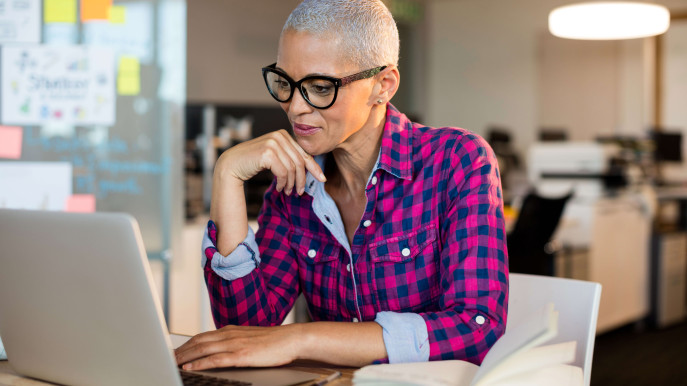 woman in an office setting on a laptop