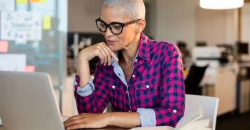 woman in an office setting on a laptop