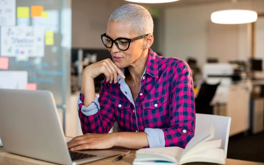 woman in an office setting on a laptop