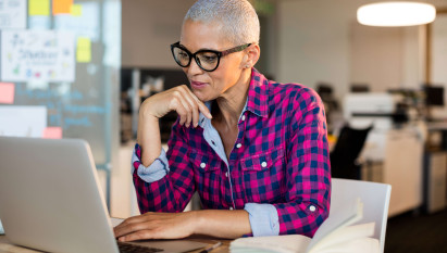 woman in an office setting on a laptop