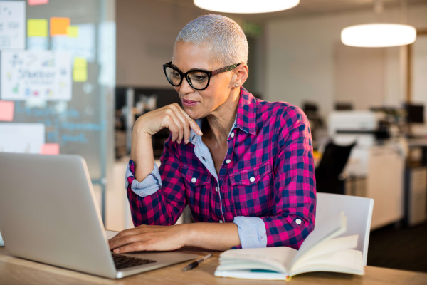 woman in an office setting on a laptop